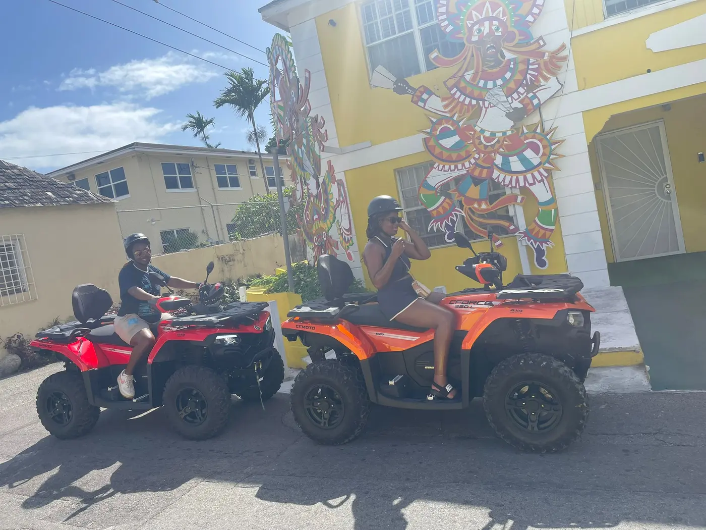 Orange ATVs in front of a mural