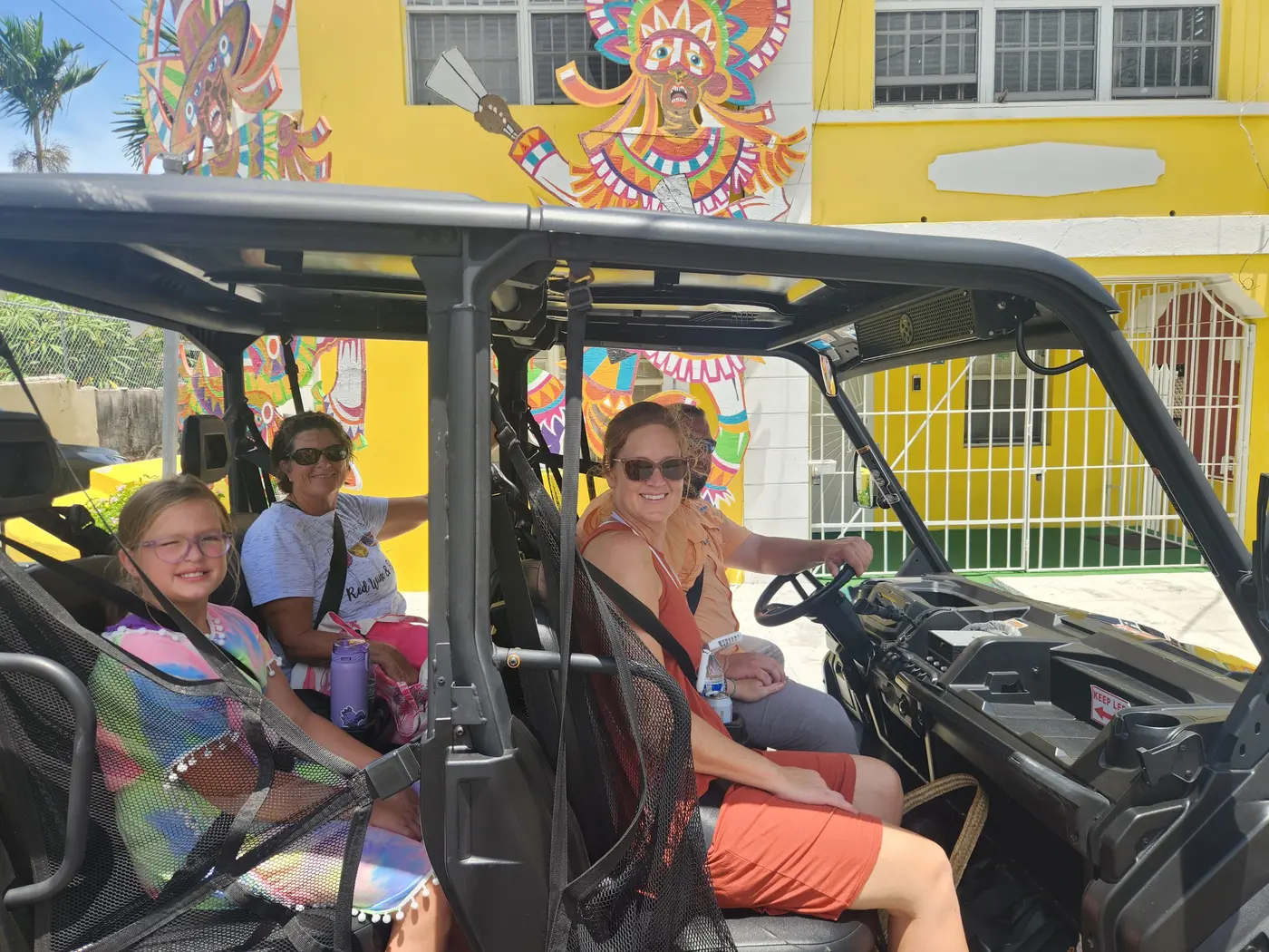 Guests in a buggy beside a mural