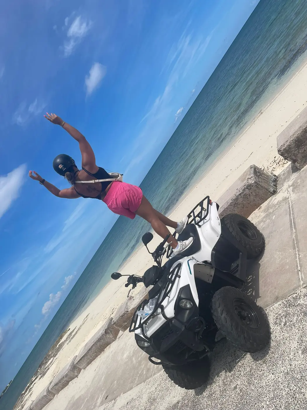A guest jumping for joy on the sea wall