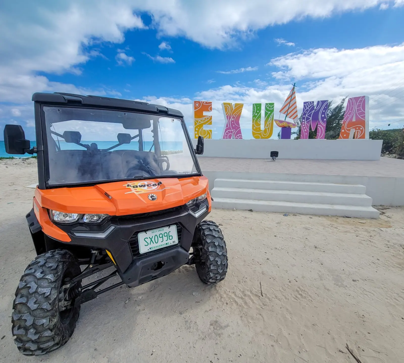 An orange Bowcar buggy parked by the colourful EXUMA sign