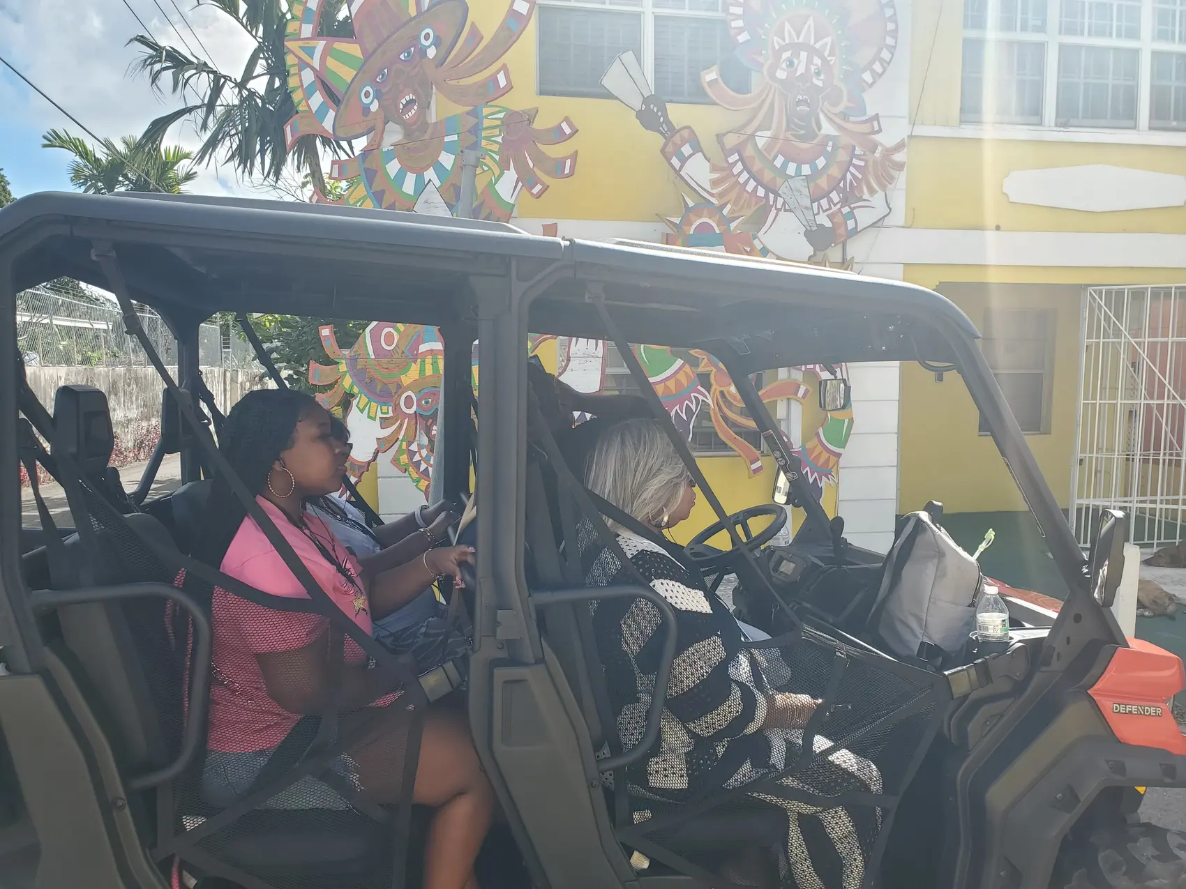 A family sitting in an open-side jeep